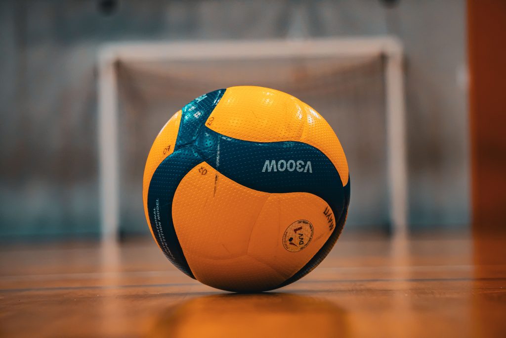 A vibrant yellow and blue volleyball on an indoor court in Kyiv, Ukraine.