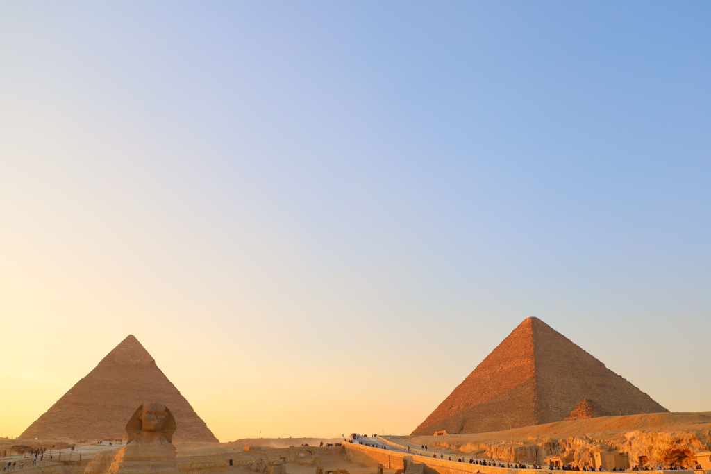 A stunning view of the Giza pyramids and Sphinx during sunset in Cairo, Egypt.