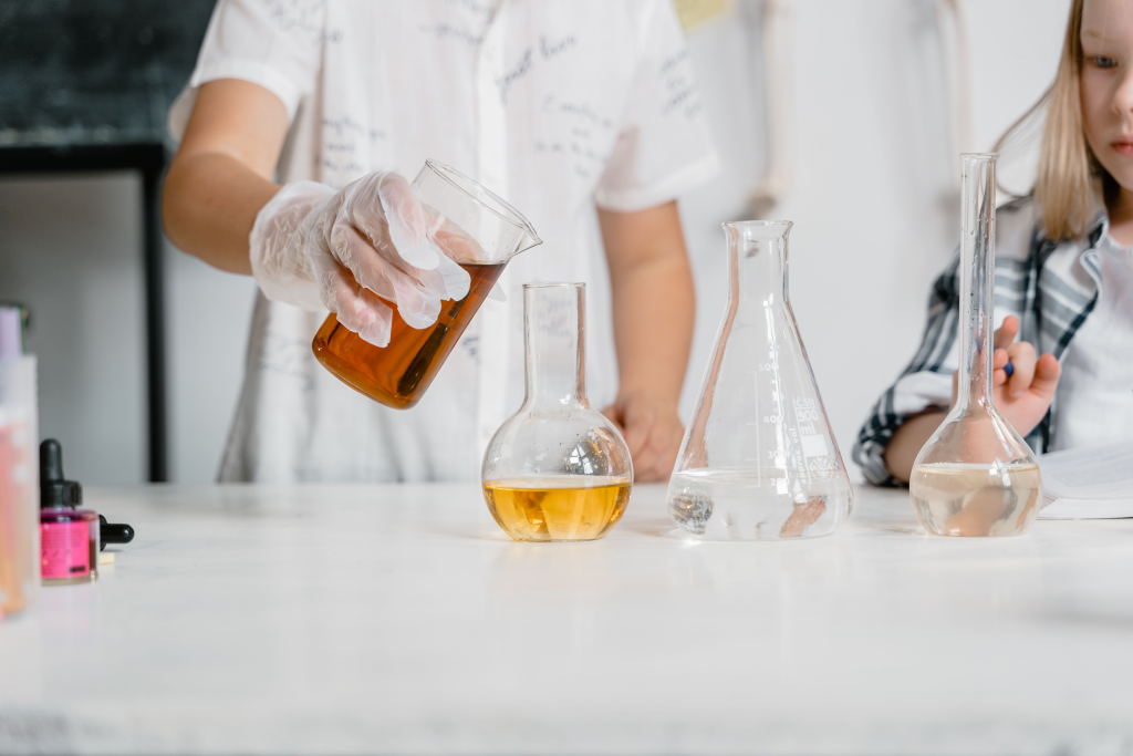 Children in a science lab conducting an experiment with beakers and liquids.