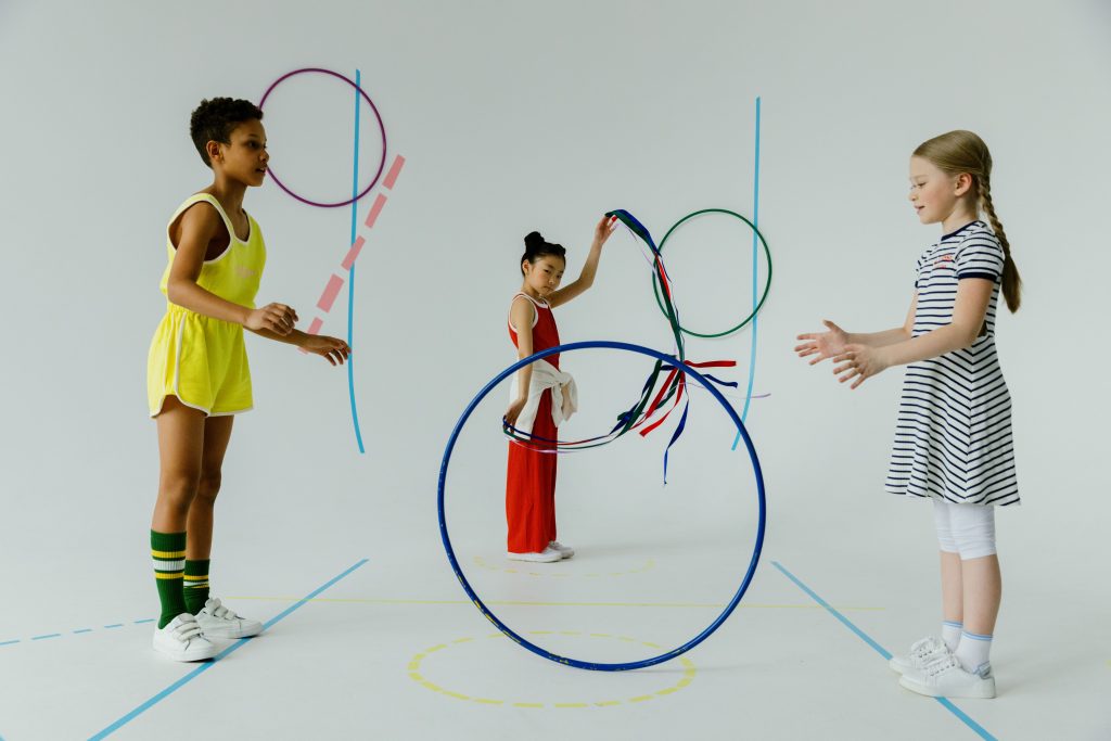 A fun indoor scene with diverse kids playing with colorful hula hoops, emphasizing play and friendship.